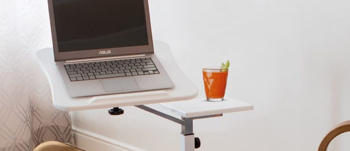 a portable laptop stand with an orange juice placed on top and next to a sofa