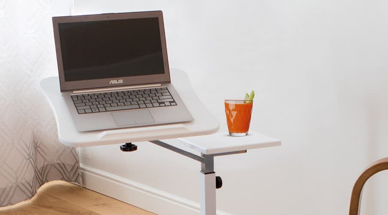 laptop stand for desk - a portable laptop stand with an orange juice placed on top and next to a sofa