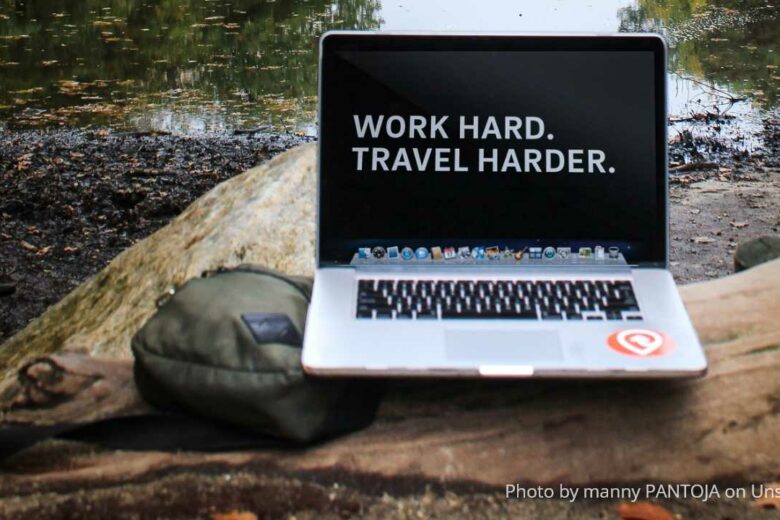 travel backpacks - a carry-on backpack and a Macbook outdoors